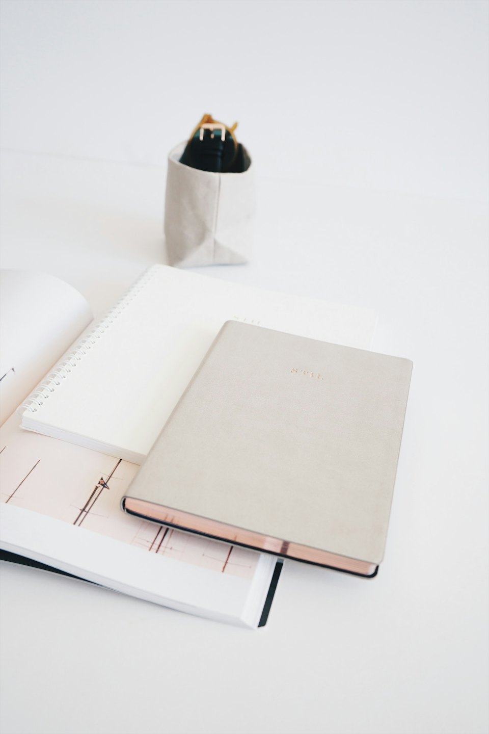 Heller beige Planer und Notizbücher auf einem sauberen Schreibtisch.