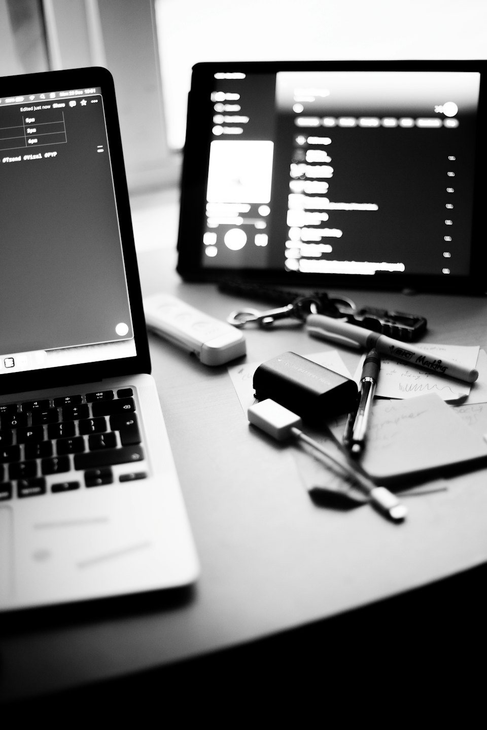 Laptop und Tablet mit Schreibtischzubehör auf einem Holztisch.